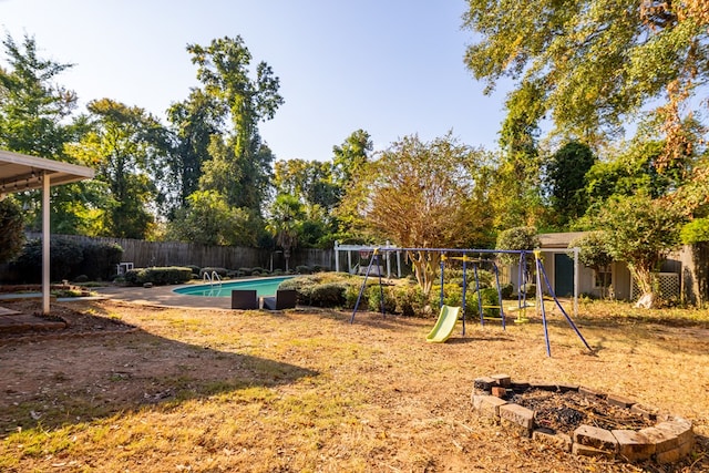 exterior space featuring a storage shed, an outdoor fire pit, and a fenced in pool