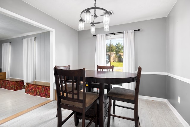 dining room featuring hardwood / wood-style flooring and a notable chandelier