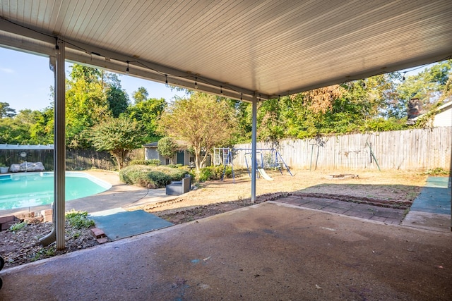 view of patio / terrace featuring a fenced in pool and a playground