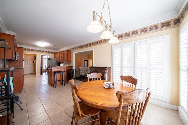 tiled dining area with sink, crown molding, and a wealth of natural light