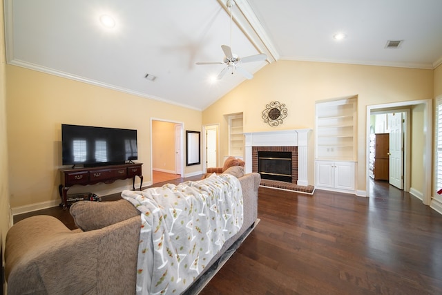 living room featuring ornamental molding, dark hardwood / wood-style flooring, built in features, ceiling fan, and a fireplace