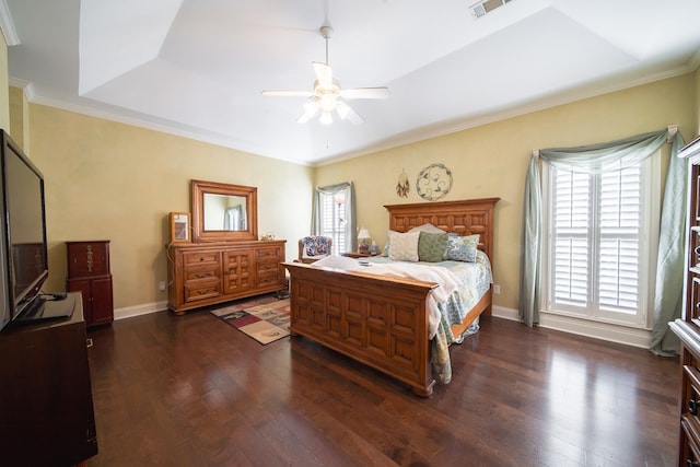 bedroom featuring dark wood-type flooring, ceiling fan, a tray ceiling, and multiple windows