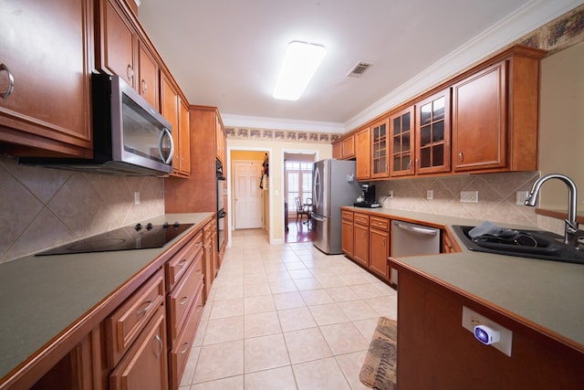 kitchen featuring sink, crown molding, black appliances, and light tile patterned floors