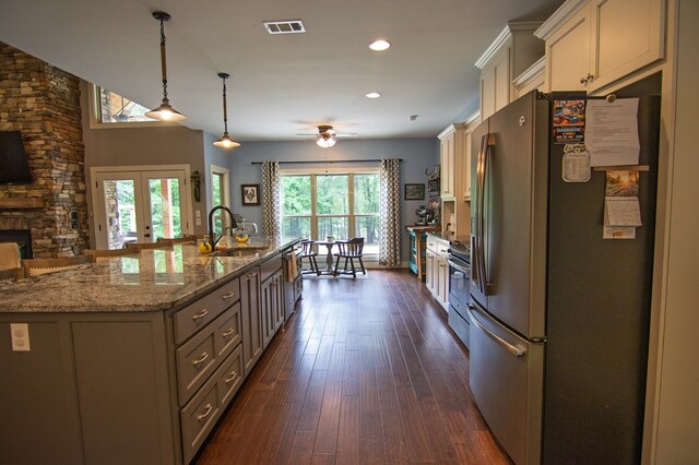 299 Savior Ln, Hamilton, GA 31811 - kitchen featuring stainless steel appliances, an island with sink, dark wood-style flooring, light stone countertops, and a ceiling fan