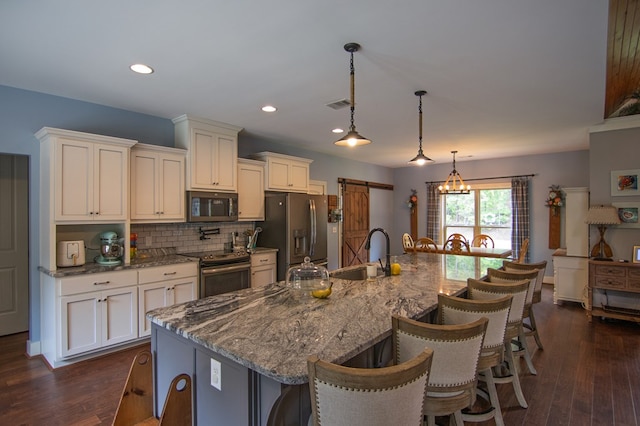 299 Savior Ln, Hamilton, GA 31811 - kitchen with stainless steel appliances, a breakfast bar, white cabinetry, tasteful backsplash, and a spacious island