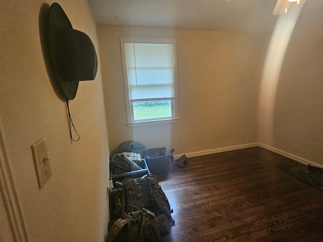 empty room with dark hardwood / wood-style flooring and ceiling fan