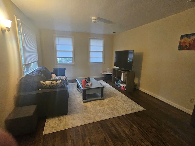 living room with dark hardwood / wood-style flooring and ceiling fan