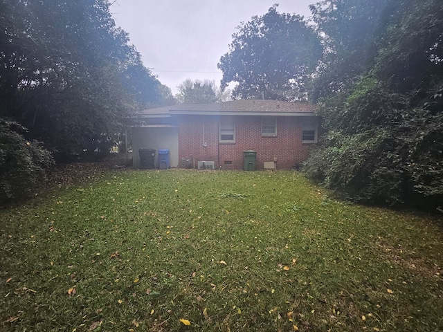 back of property featuring a lawn and central AC