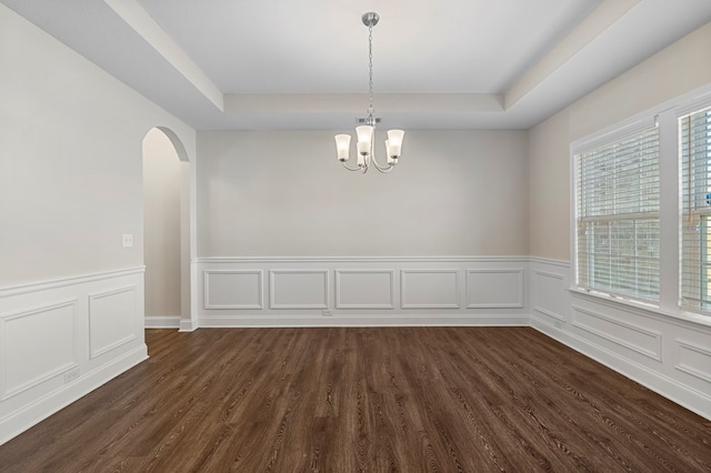 254 Clearbrook Ln, Columbus, GA 31904 - empty room featuring a tray ceiling, a chandelier, dark wood-style flooring, arched walkways, and wainscoting