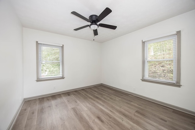 unfurnished room featuring ceiling fan, baseboards, and light wood-type flooring