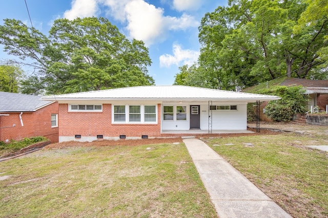 ranch-style house with a front lawn, brick siding, a porch, and metal roof