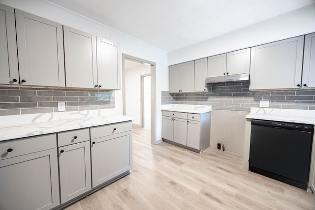 kitchen with light stone counters, tasteful backsplash, dishwasher, light wood-style flooring, and gray cabinetry