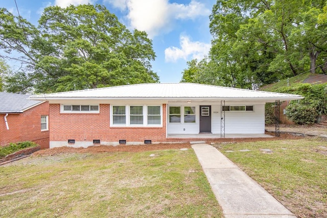 ranch-style home featuring metal roof, brick siding, a front lawn, and covered porch