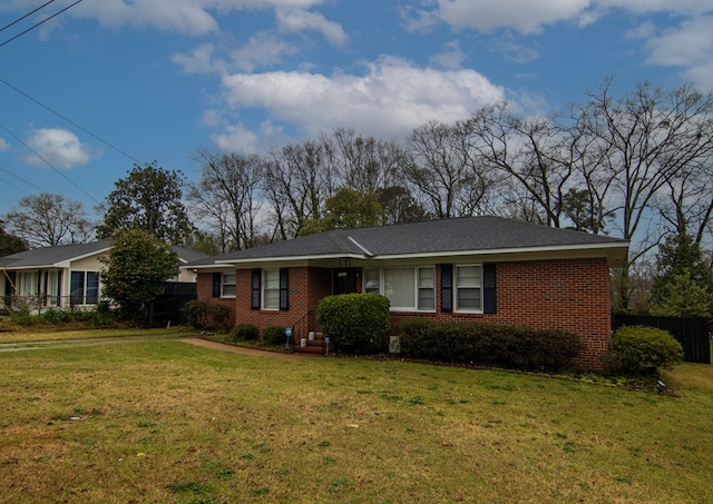 ranch-style house with a front yard, fence, and brick siding