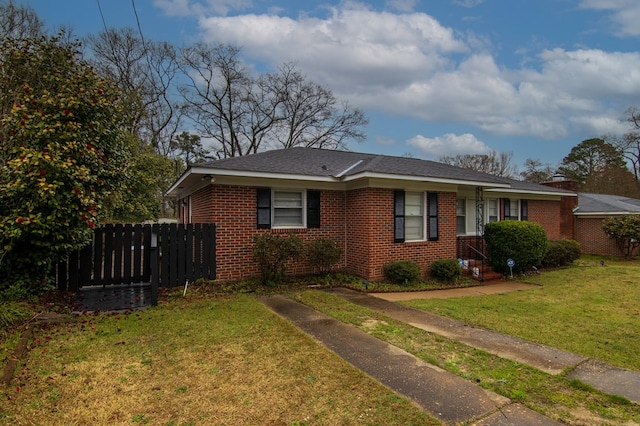 view of front of property featuring brick siding, a front yard, and fence