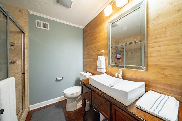 bathroom featuring a shower stall, visible vents, wooden walls, ornamental molding, and wood finished floors
