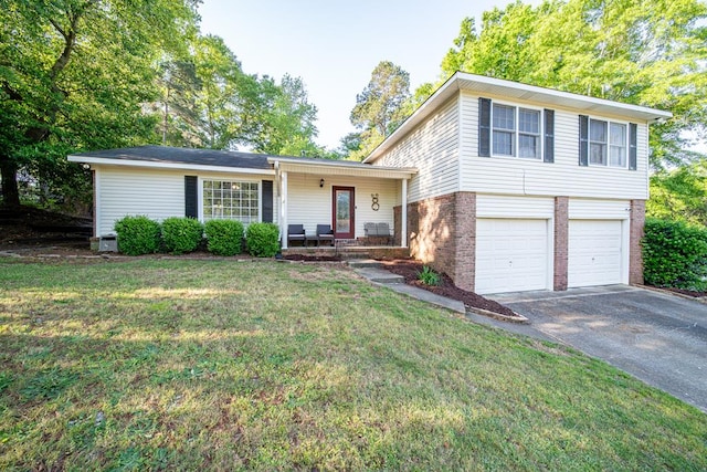 tri-level home with a porch, a front yard, driveway, brick siding, and an attached garage