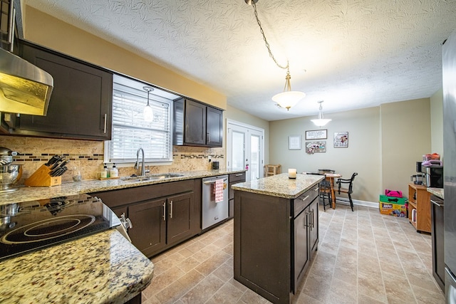 kitchen with stainless steel dishwasher, a sink, backsplash, and plenty of natural light