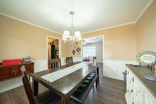 dining area with ornamental molding, a textured ceiling, a chandelier, and dark wood finished floors