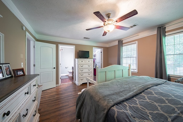 bedroom featuring dark wood finished floors, a spacious closet, visible vents, and a textured ceiling