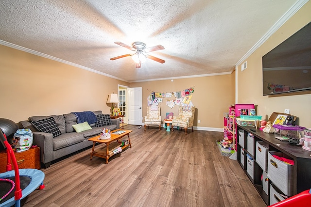 living room featuring wood finished floors, a ceiling fan, a textured ceiling, and crown molding