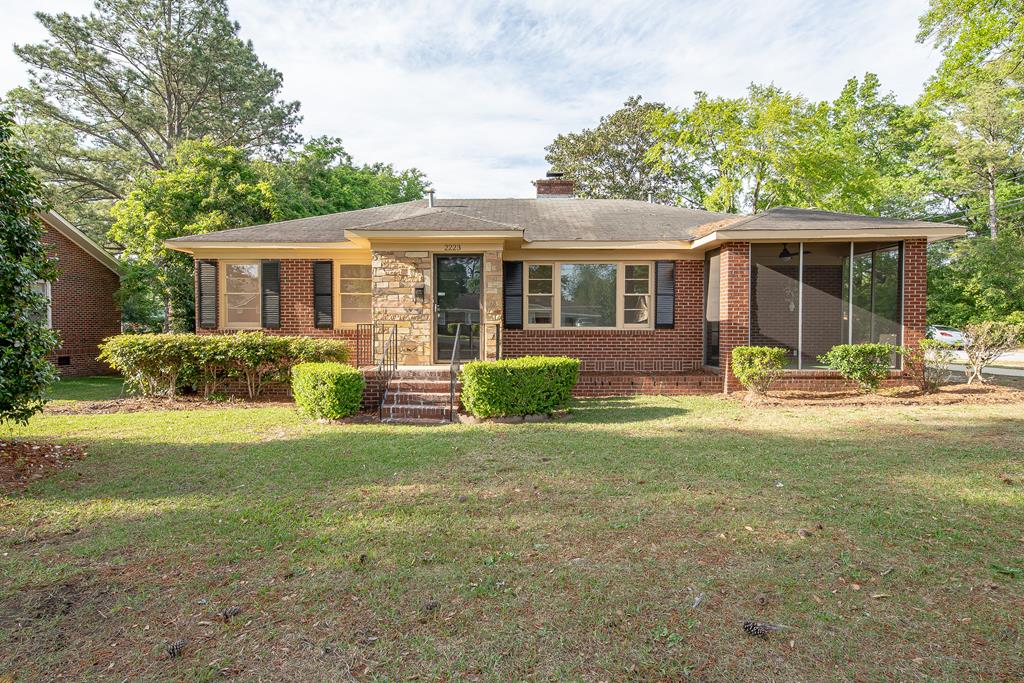 2223 51st St, Columbus, GA 31904 - ranch-style home with brick siding, a front yard, a sunroom, and a chimney