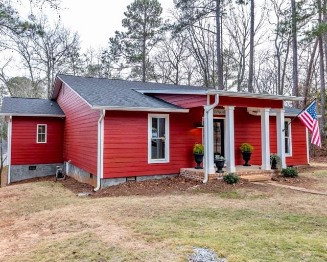 view of front of home with a porch, crawl space, a shingled roof, and a front lawn