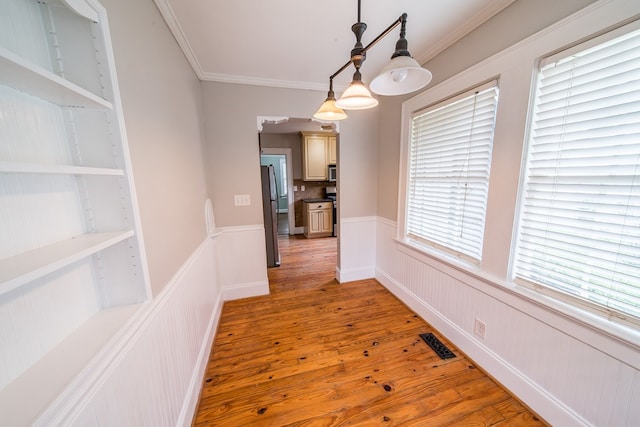 dining room featuring wood-type flooring and crown molding