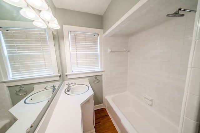 bathroom featuring hardwood / wood-style flooring, vanity, and tiled shower / bath combo