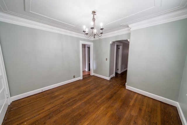 spare room featuring ornamental molding, an inviting chandelier, and dark hardwood / wood-style flooring