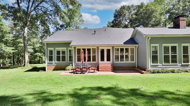 rear view of property with a lawn and a patio