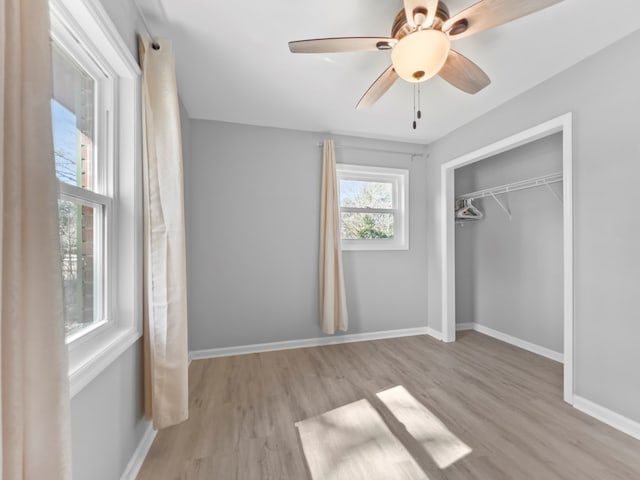 unfurnished bedroom featuring ceiling fan, light hardwood / wood-style floors, and a closet