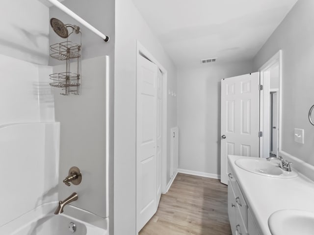 bathroom featuring hardwood / wood-style flooring, vanity, and shower / bathing tub combination