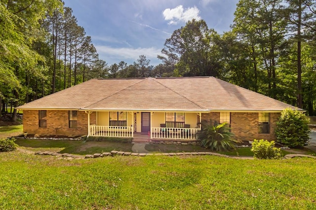 ranch-style home featuring covered porch and a front yard