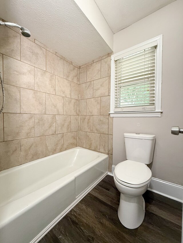 3068 Apache Dr, Columbus, GA 31909 - full bath featuring wood finished floors, toilet, baseboards, a textured ceiling, and washtub / shower combination