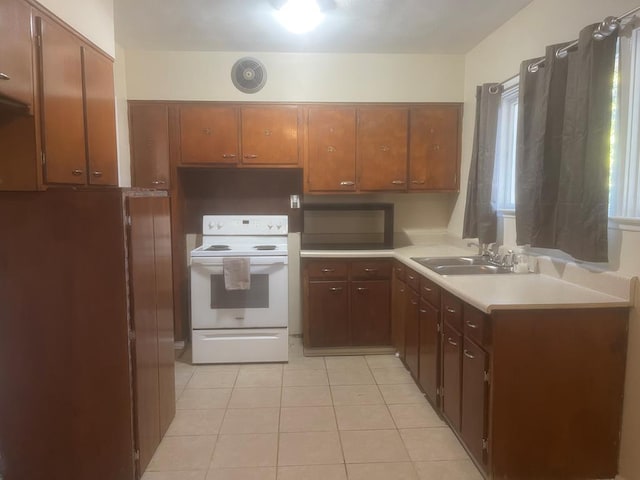 kitchen with light tile patterned flooring, sink, and white electric stove