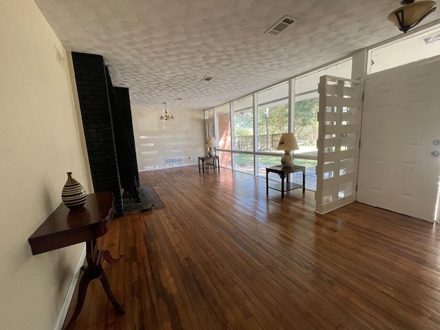 interior space with a textured ceiling, floor to ceiling windows, and dark wood-type flooring