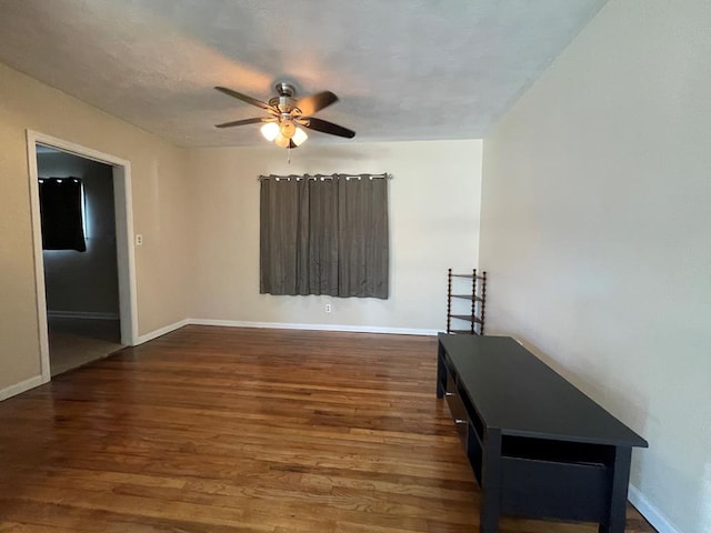 empty room with dark hardwood / wood-style flooring and ceiling fan