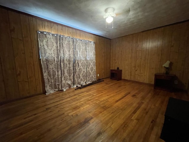 unfurnished room featuring hardwood / wood-style floors and wood walls