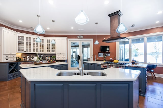 kitchen featuring hanging light fixtures, white cabinetry, and a large island with sink