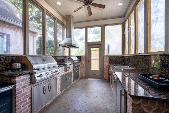 sunroom featuring wood ceiling, ceiling fan, and sink