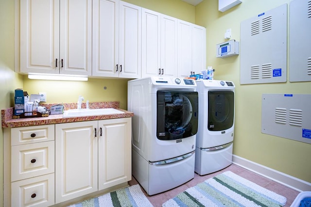 laundry area featuring separate washer and dryer, sink, and cabinets