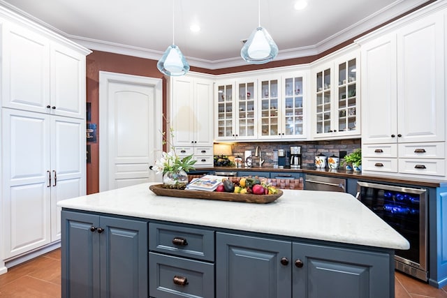 kitchen featuring pendant lighting, stainless steel dishwasher, beverage cooler, and white cabinets