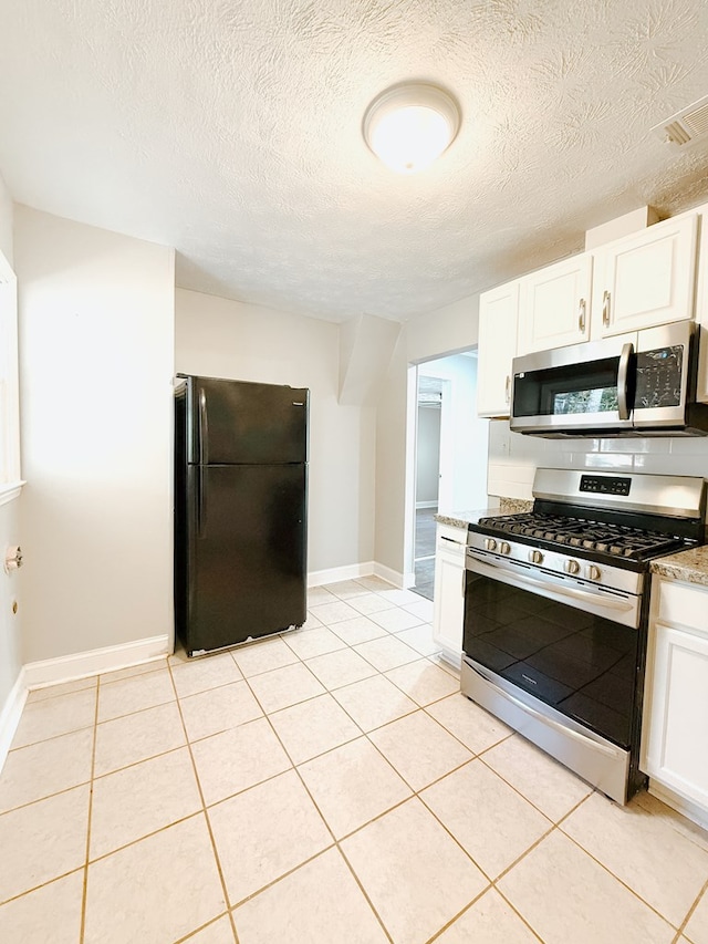 kitchen with white cabinetry, light tile patterned floors, baseboards, and stainless steel appliances