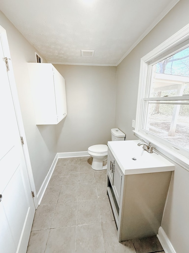 half bath with tile patterned floors, visible vents, toilet, and baseboards