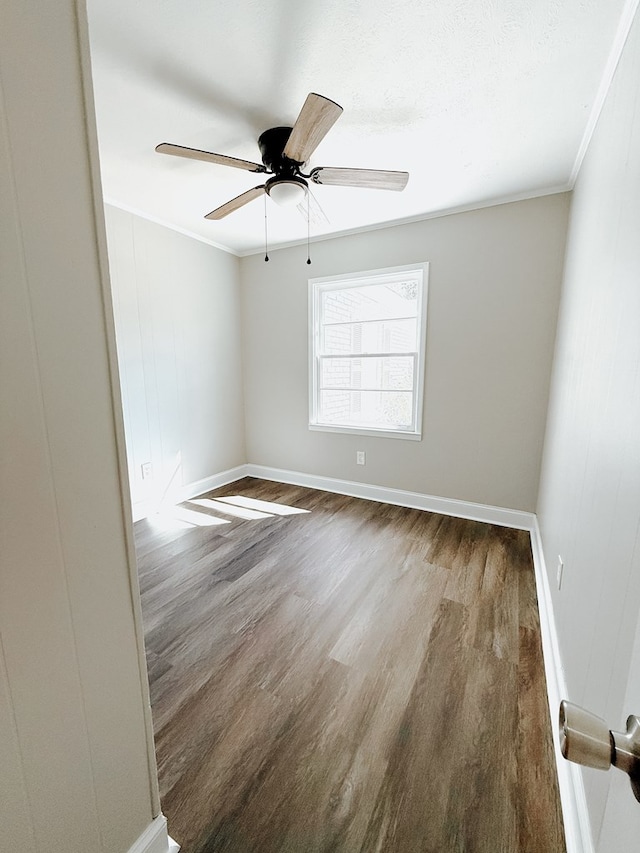 unfurnished room featuring ceiling fan, baseboards, wood finished floors, and crown molding