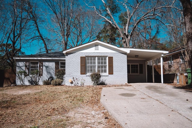 view of front facade with an attached carport, brick siding, and driveway