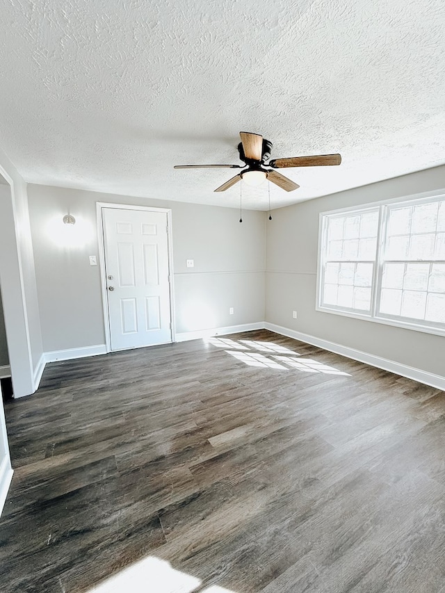 spare room featuring a textured ceiling, wood finished floors, baseboards, and ceiling fan