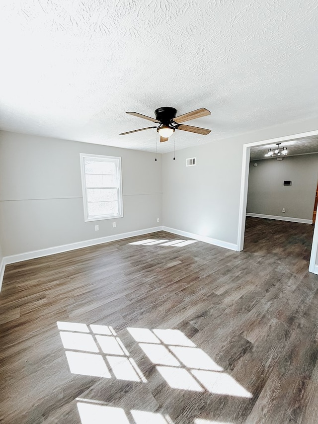 unfurnished room featuring visible vents, a textured ceiling, wood finished floors, baseboards, and ceiling fan