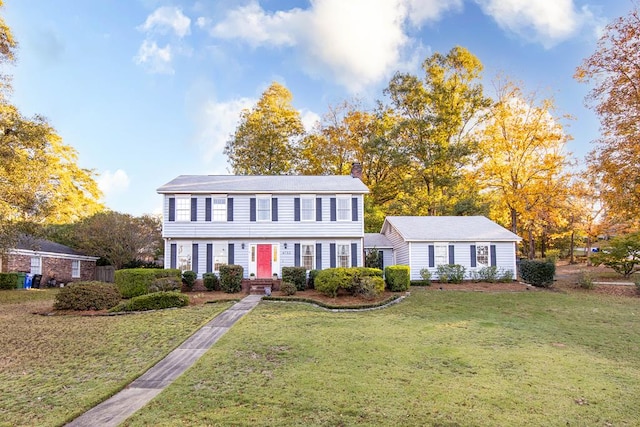 colonial inspired home with a front lawn